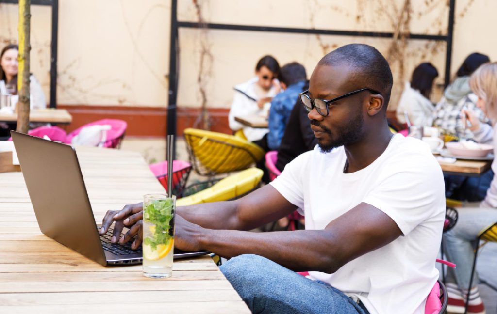 Remote workers on laptops at a coworking space in a popular workcation destination.